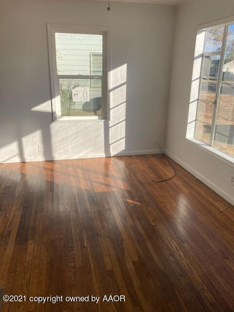 4608 Preston Street Amarillo, TX 79110 - Photo 2 of 9 an empty room with wooden floor and windows