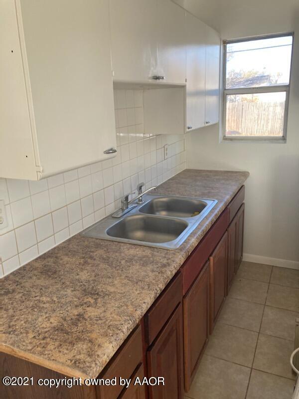 4608 Preston Street Amarillo, TX 79110 - Photo 4 of 9 a kitchen with a sink a counter top space and cabinets