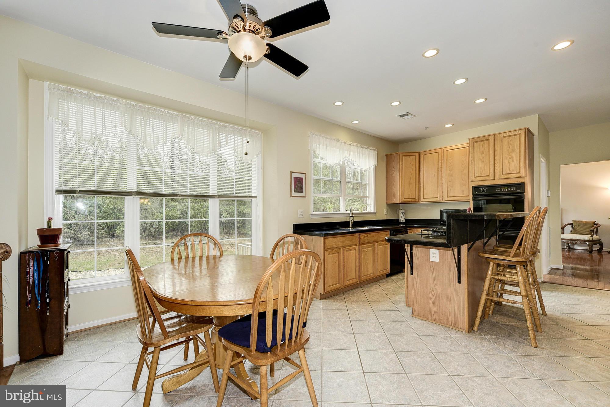 11204 Snowden Pond Road Laurel, MD 20708 - Photo 12 of 30 a kitchen with a dining table chairs and white cabinets