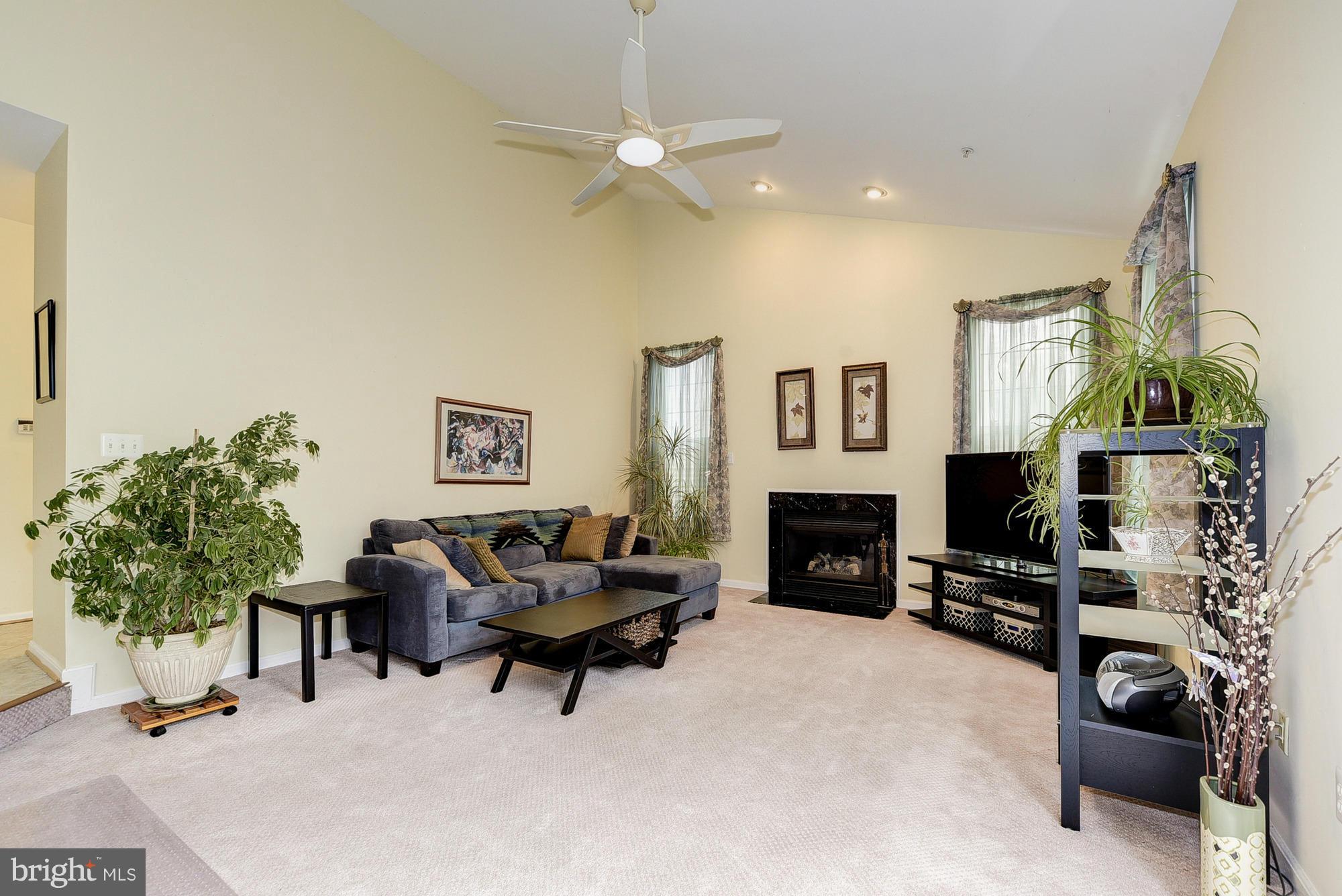 11204 Snowden Pond Road Laurel, MD 20708 - Photo 13 of 30 a living room with furniture a fireplace and a flat screen tv