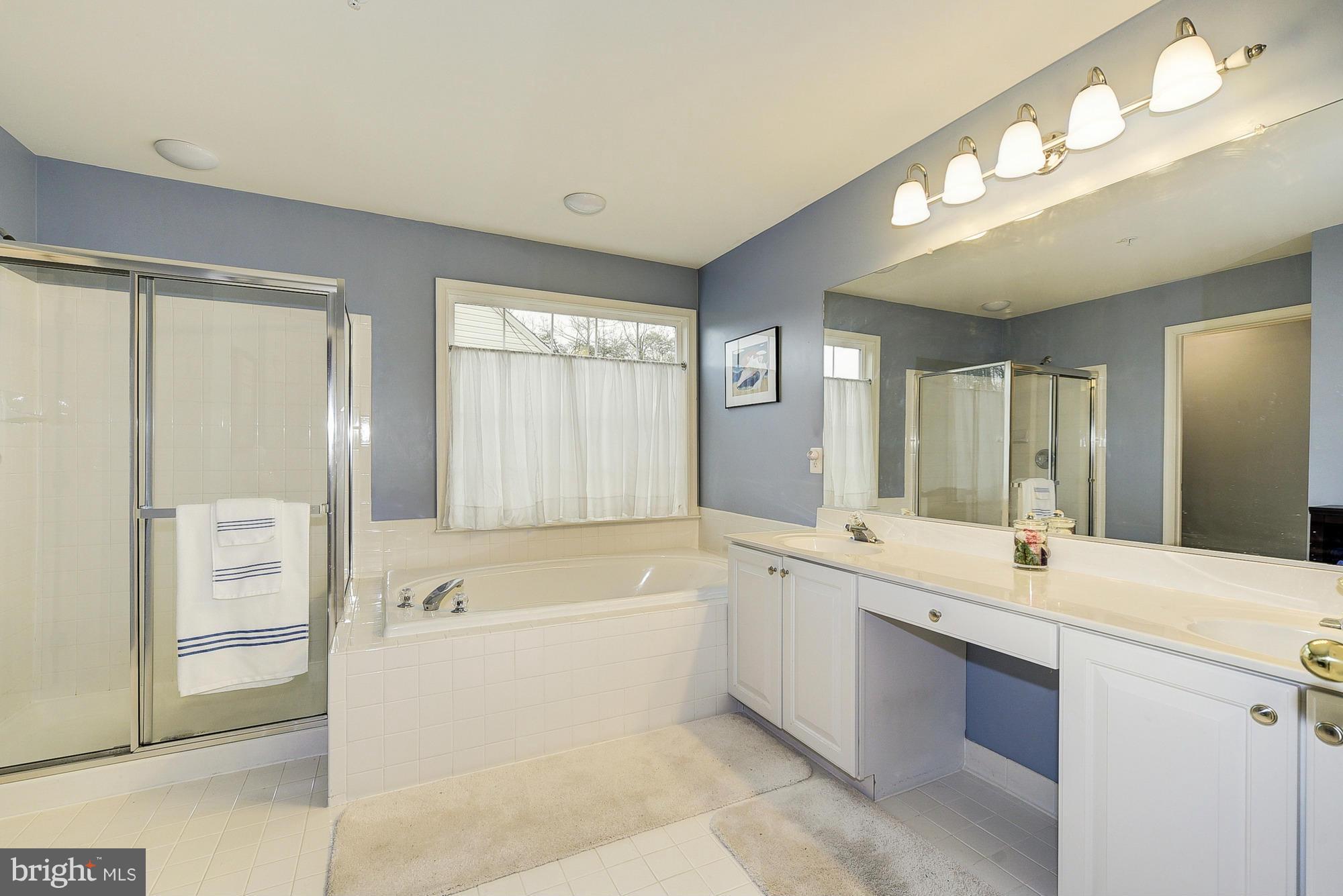11204 Snowden Pond Road Laurel, MD 20708 - Photo 19 of 30 a large bathroom with a large tub shower and sink