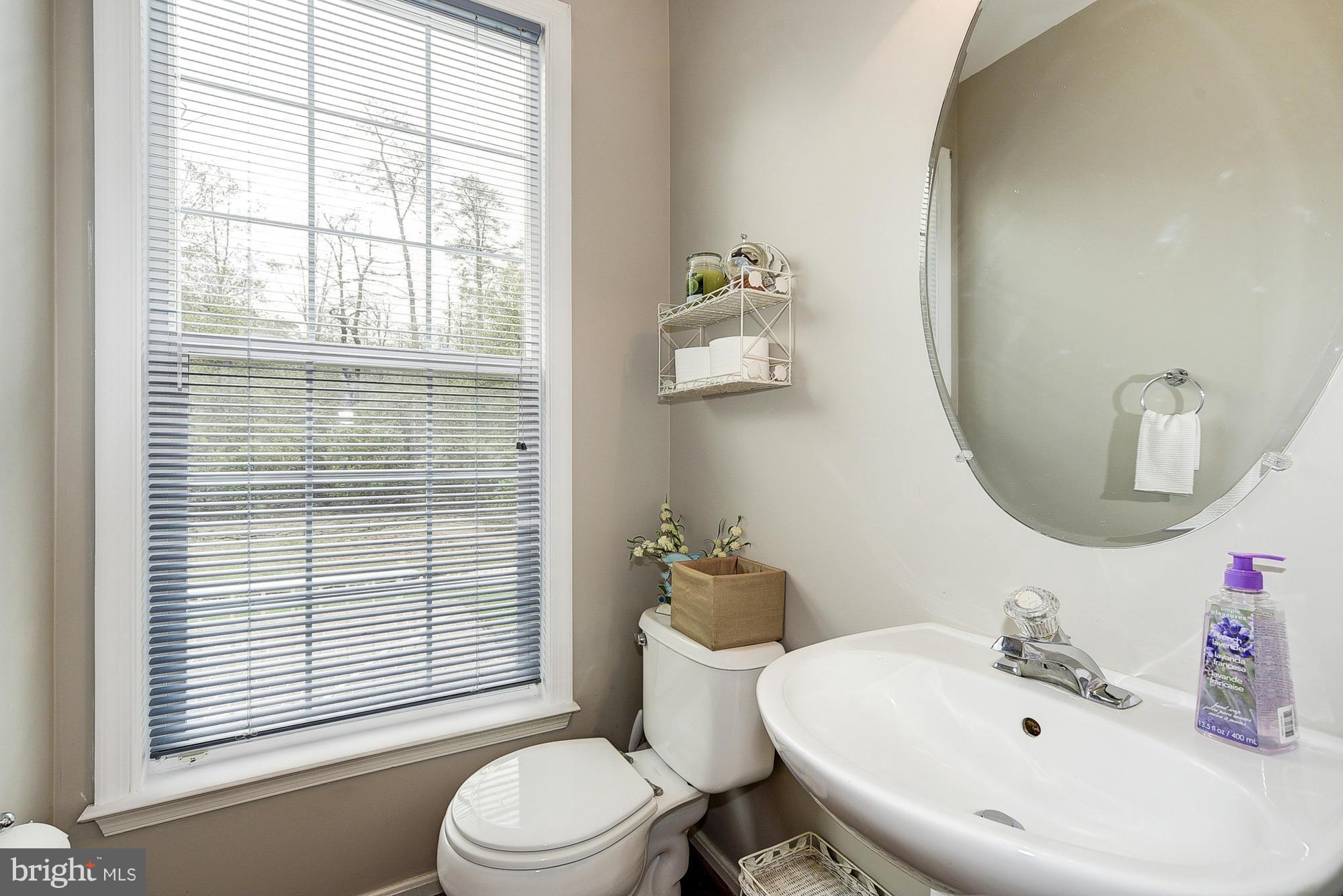 11204 Snowden Pond Road Laurel, MD 20708 - Photo 7 of 30 a bathroom with a sink a toilet and a mirror