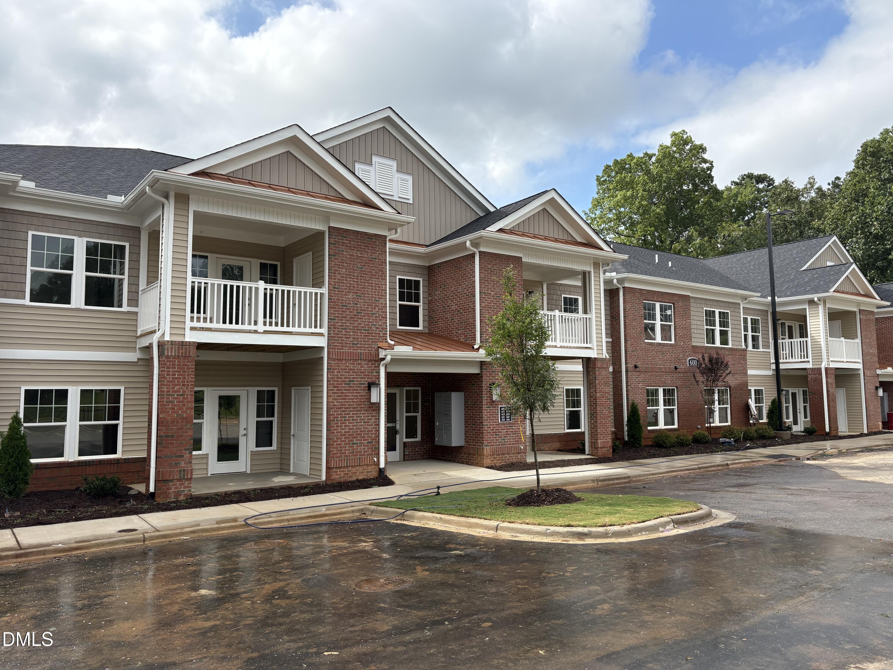 618 Weather Ridge Lane, Unit 28 Cary, NC 27513 - Photo 25 of 27 a front view of a residential apartment building with a yard