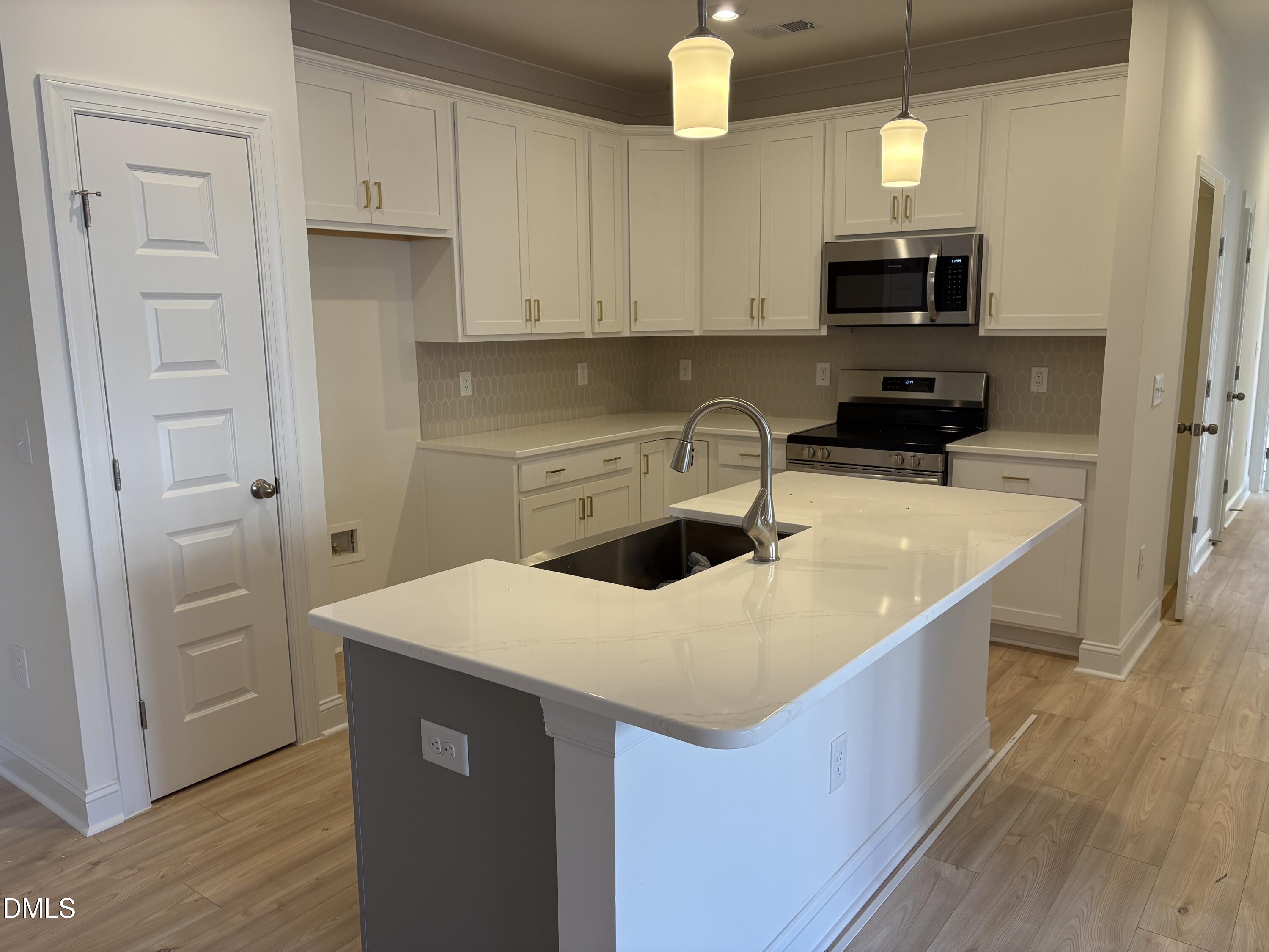 618 Weather Ridge Lane, Unit 28 Cary, NC 27513 - Photo 4 of 27 a kitchen with a sink a stove and cabinets