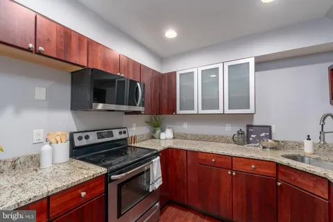 a kitchen with stainless steel appliances granite countertop a sink stove and microwave