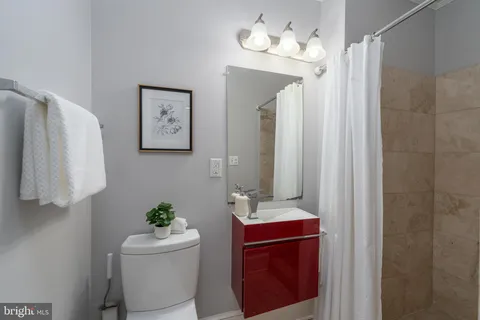 a bathroom with a sink vanity granite and toilet