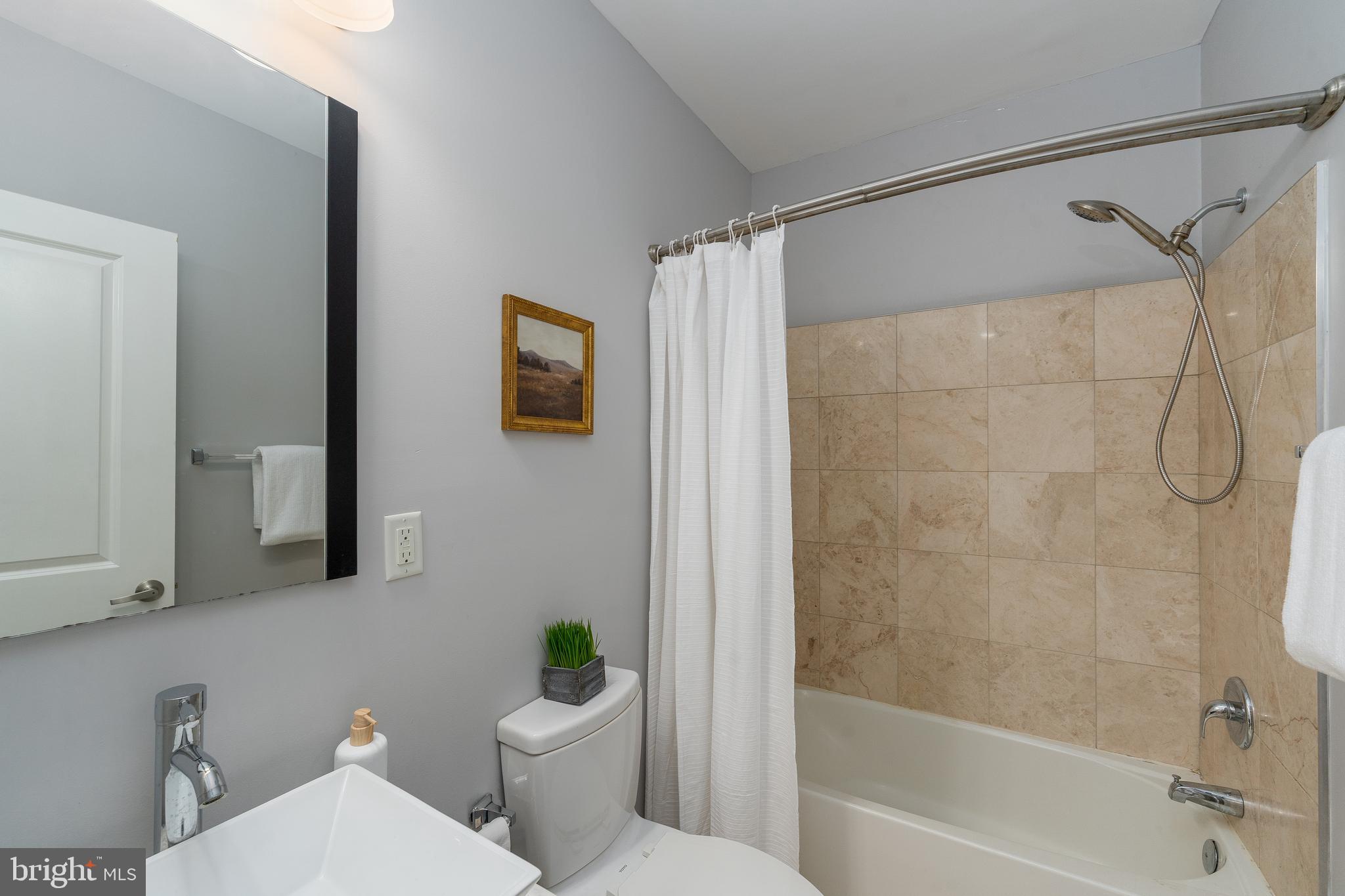 15 West Biddle Street, Unit 15C Baltimore, MD 21201 - Photo 23 of 33 a white toilet sitting next to a bath tub shower