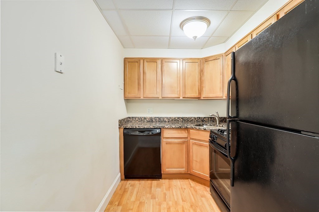 1500 Worcester Road, Unit 710 Framingham, MA 01702 - Photo 7 of 33 a kitchen with a refrigerator and a stove top oven