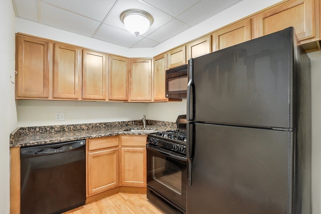 1500 Worcester Road, Unit 710 Framingham, MA 01702 - Photo 8 of 33 a kitchen with a sink a refrigerator and cabinets