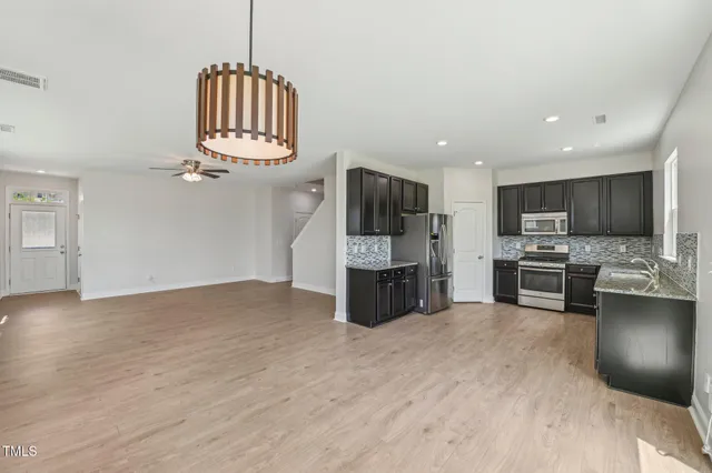 a kitchen with stainless steel appliances a refrigerator sink and microwave
