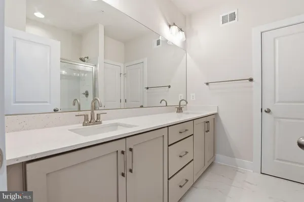 a bathroom with a double vanity sink and mirror