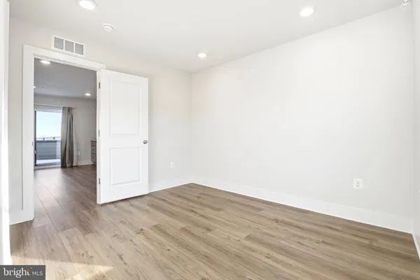 a view of a room with wooden floor and a hallway