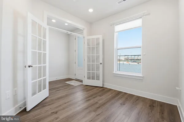an empty room with wooden floor and windows