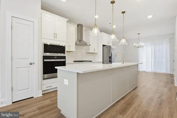 a kitchen with kitchen island a sink stainless steel appliances and cabinets
