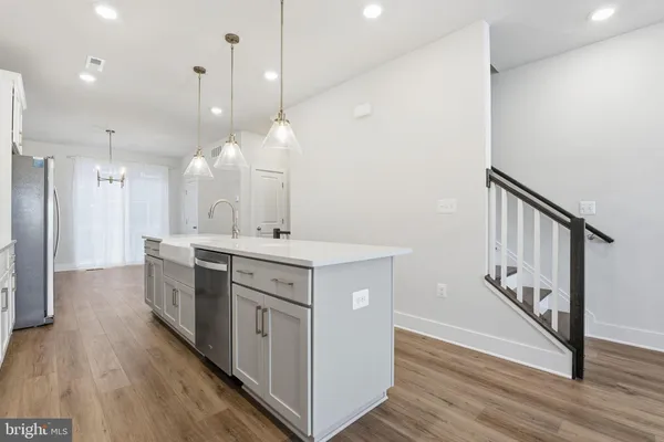 a kitchen with kitchen island a sink and a stove top oven