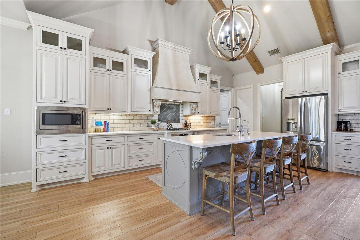 1202 North 14th Place Wolfforth, TX 79382 - Photo 24 of 75 a kitchen with cabinets stainless steel appliances and wooden floor