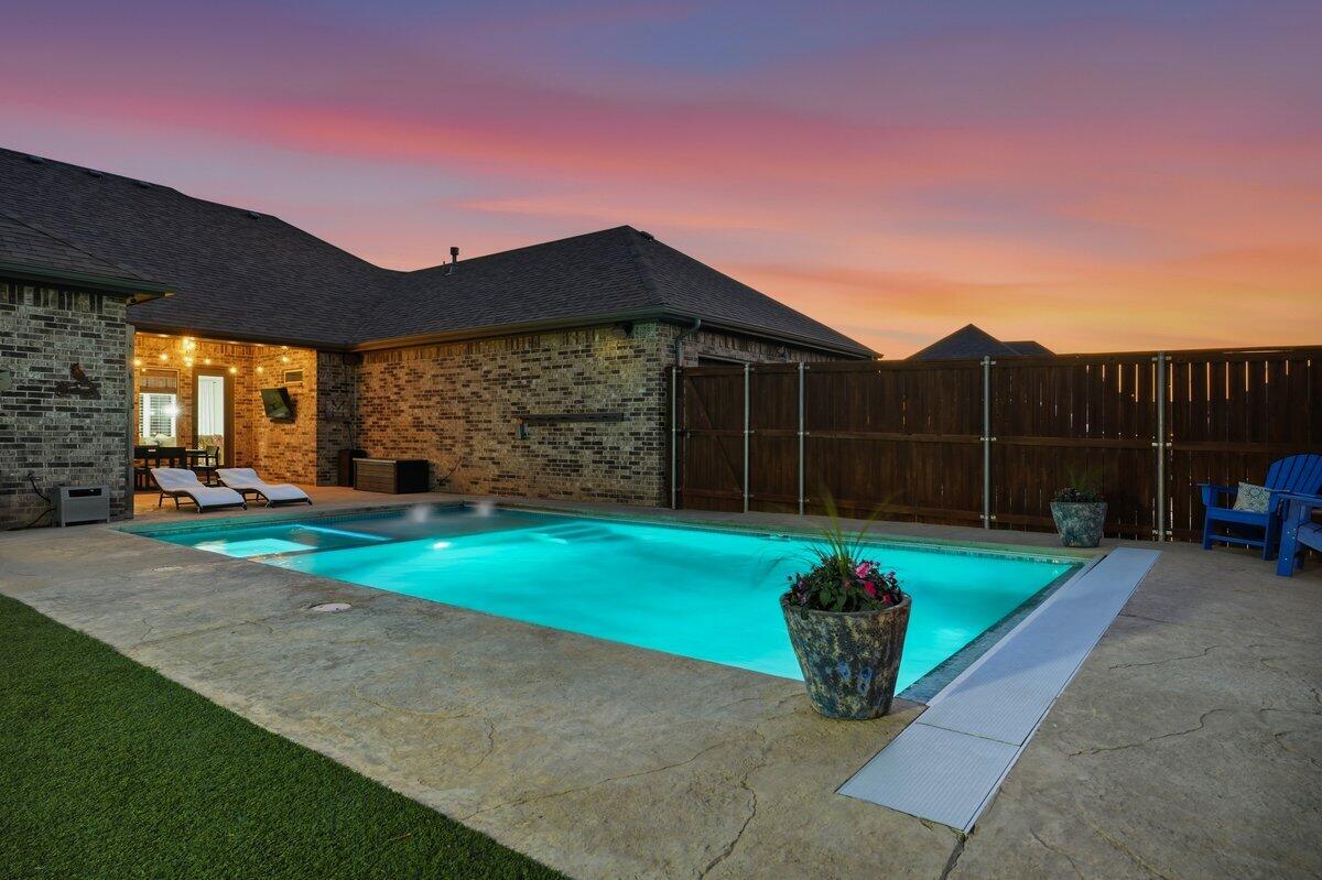 1202 North 14th Place Wolfforth, TX 79382 - Photo 72 of 75 a view of a backyard with table and chairs plants and wooden fence