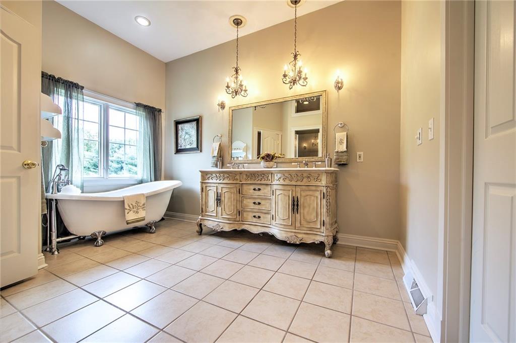 118 Klein Road Cranberry Township, PA 16066 - Photo 13 of 25 Master bath has tile flooring, double bowl granite sink with ornate vanity and chandelier lighting, clawfoot tub, tile shower with glass door, private toilet, speaker and walk-in closet.
