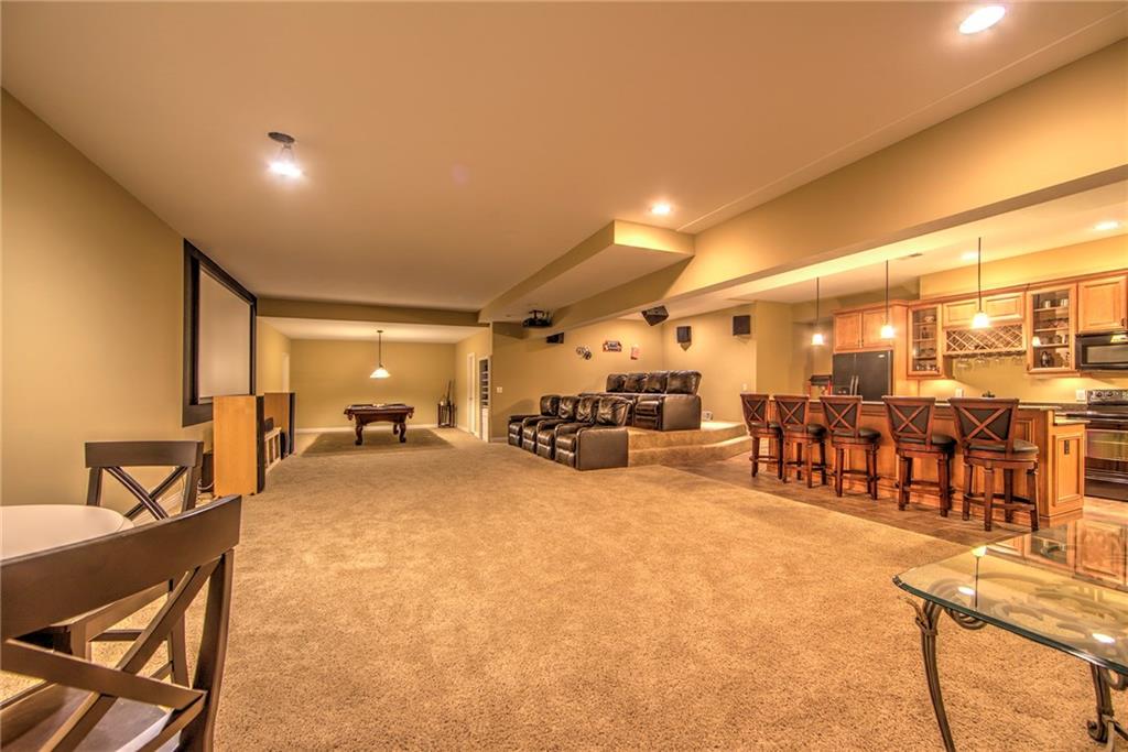 118 Klein Road Cranberry Township, PA 16066 - Photo 21 of 25 46x35 Gameroom features a theater with surround sound (double-drywalled ceiling with metal track system over the theater room for extra soundproofing), custom built-in entertainment nook, full kitchen with tile flooring, quartz countertops, 2-tier island, rich cabinetry with built-in wine rack, double-bowl sink and pendant lighting, large storage room, game closet, 2 mechanical rooms, half bath with tile flooring and a spacious, 19x16 den.