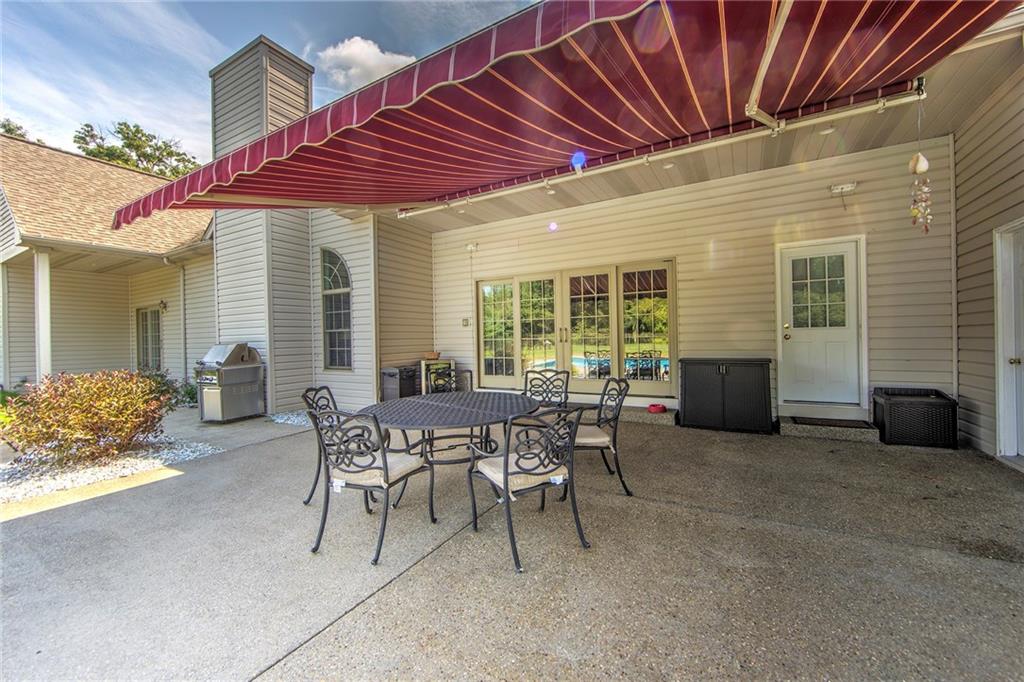 118 Klein Road Cranberry Township, PA 16066 - Photo 23 of 25 Aggregate and stamped concrete patio includes remote retractable awning, hot and cold faucet, speakers, built-in firepit, and outdoor beverage cooler.
