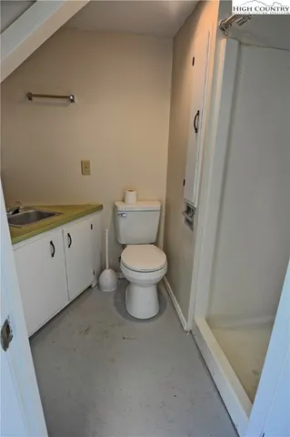 a bathroom with a granite countertop toilet a sink and a shower