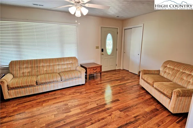 a living room with furniture and wooden floor