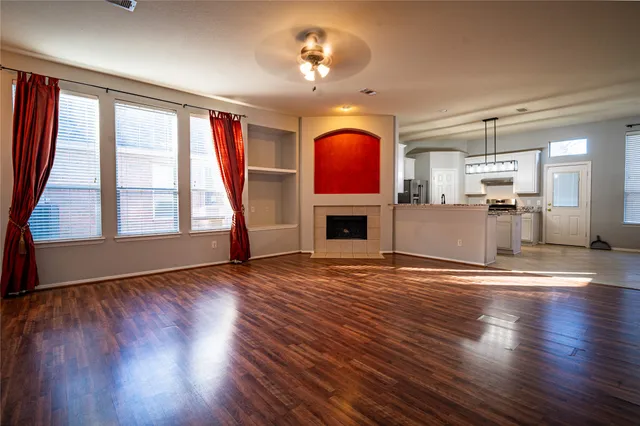 a view of empty room with fireplace and wooden floor