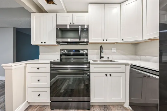 a kitchen with white cabinets and stainless steel appliances