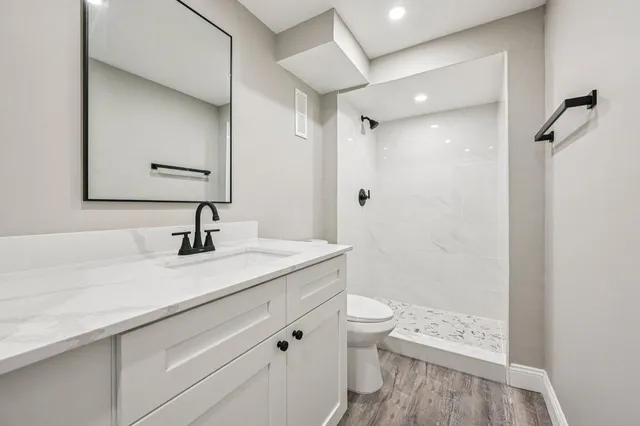 a bathroom with a granite countertop sink toilet and shower