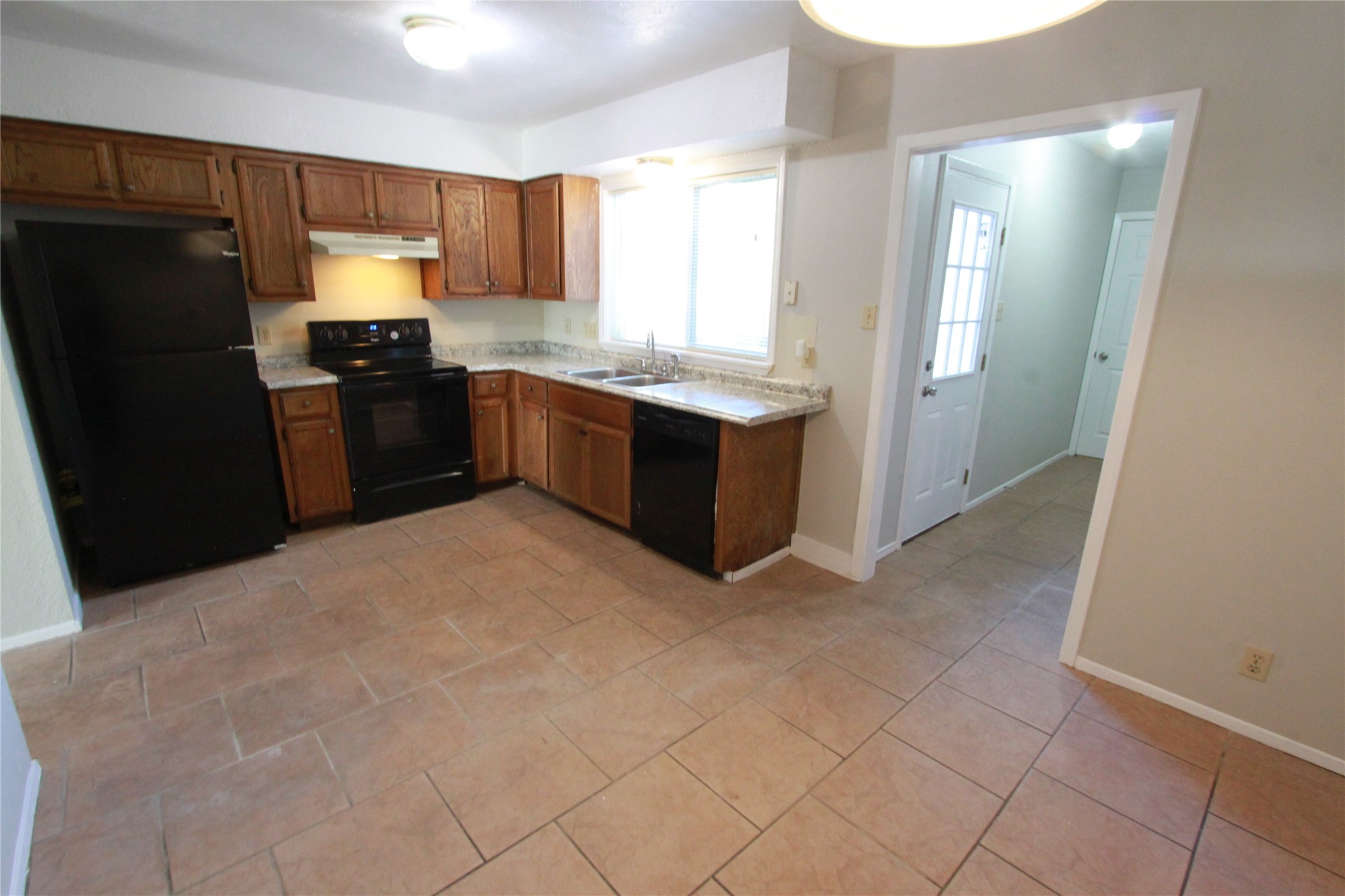 3904 Hudson Bend Road, Unit D Austin, TX 78734 - Photo 12 of 25 Kitchen featuring black appliances, light countertops, brown cabinets, and under cabinet range hood