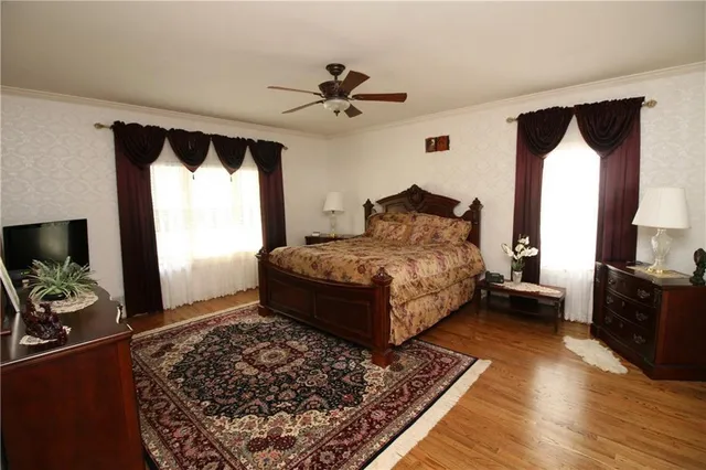 a bedroom with a bed and a flat tv screen on dresser