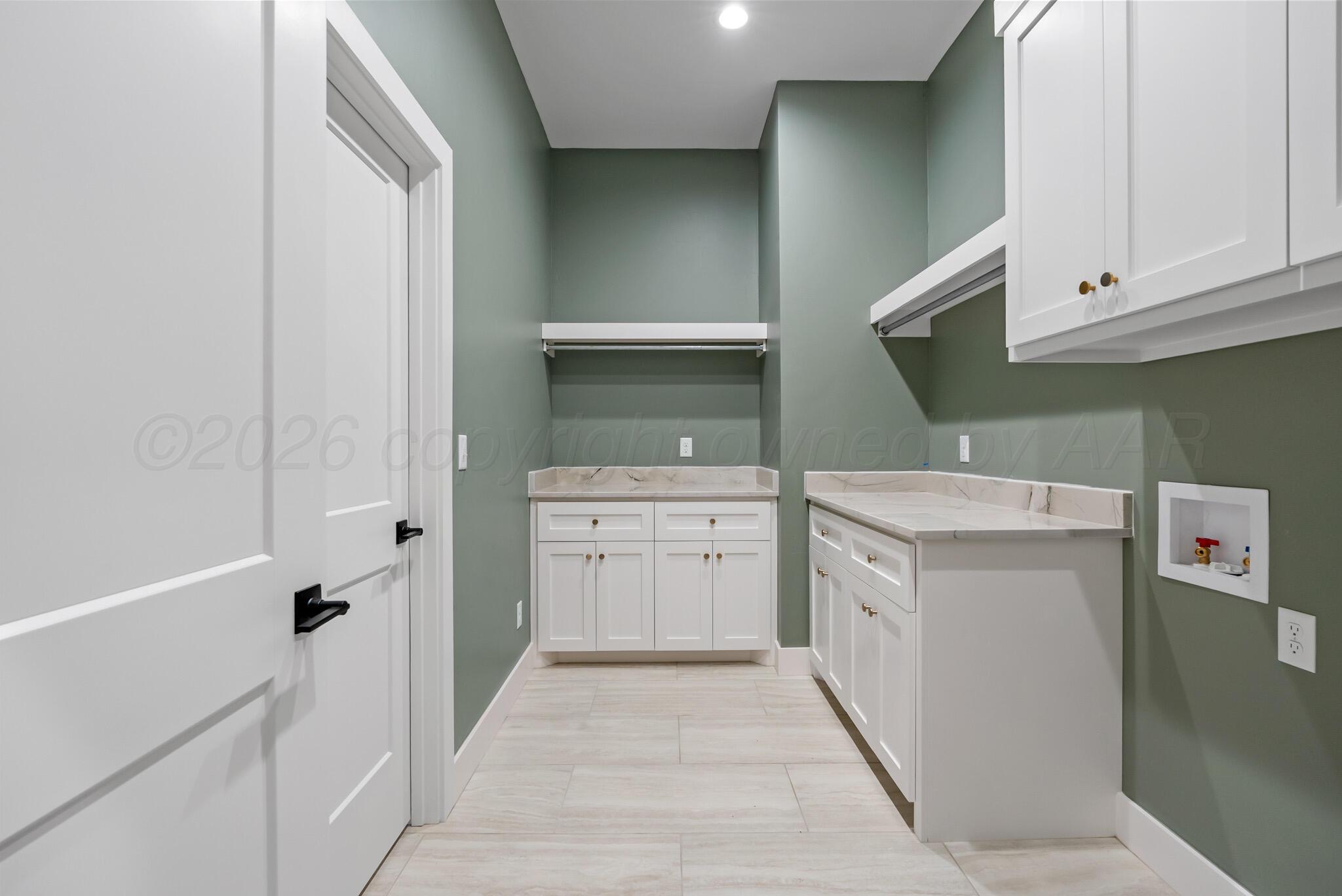 4201 Juniper Springs Road Amarillo, TX 79119 - Photo 11 of 27 a utility room with cabinets washer and dryer