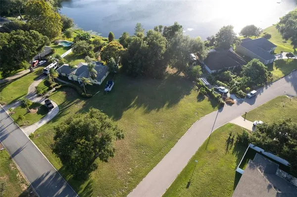 an aerial view of a house a yard and a lake view