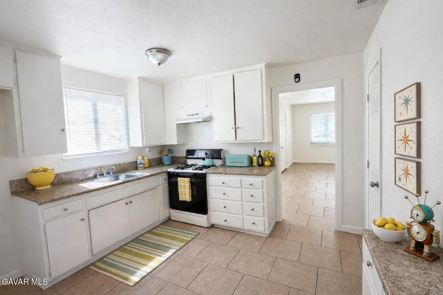 44226 2nd Street East Lancaster, CA 93535 - Photo 4 of 24 a kitchen with stainless steel appliances sink stove and cabinets