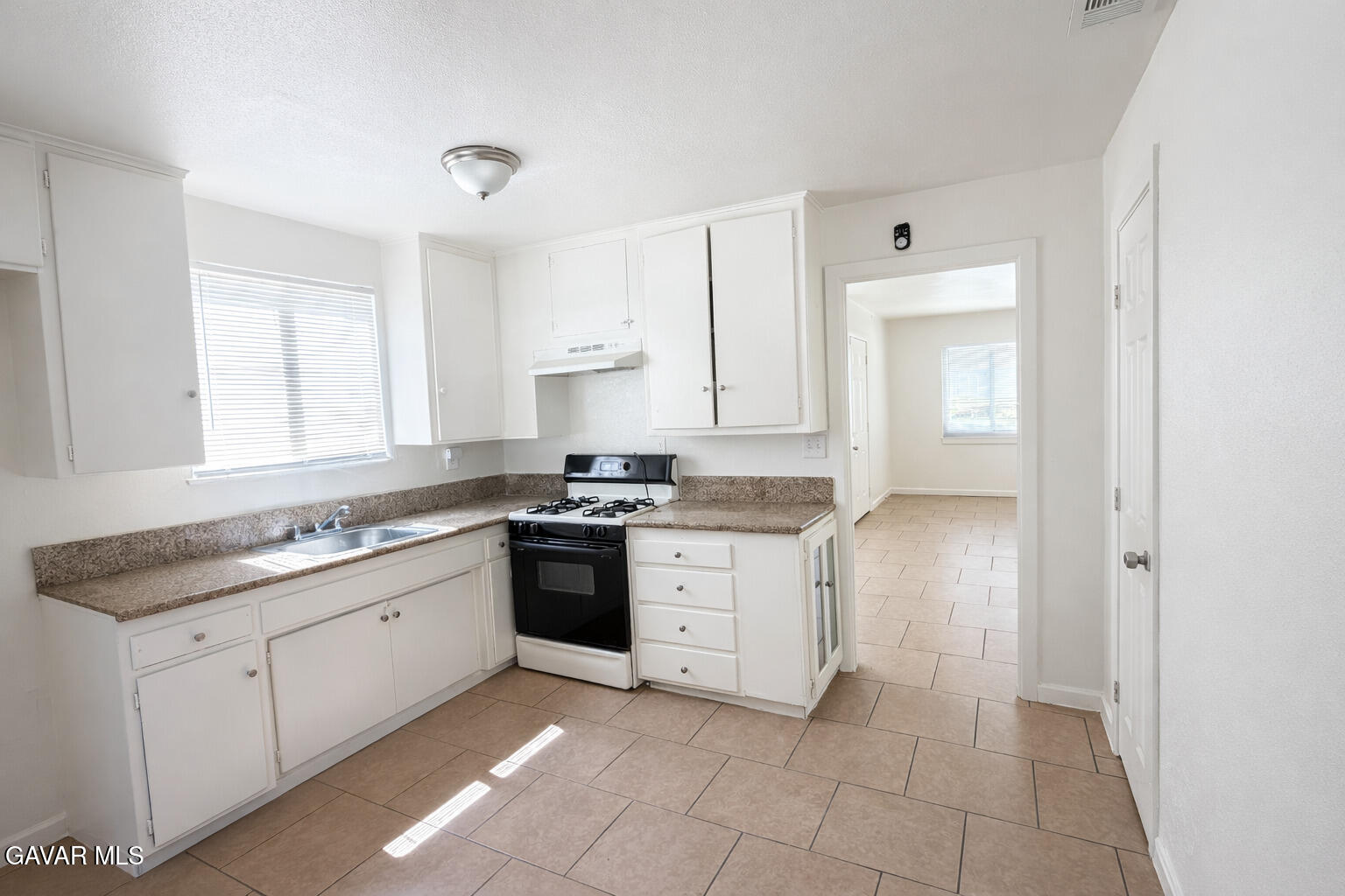 44226 2nd Street East Lancaster, CA 93535 - Photo 5 of 24 a kitchen with a stove sink and cabinets