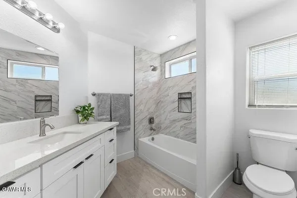 a bathroom with a granite countertop sink toilet and shower