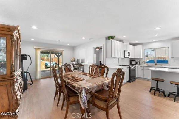 a view of a dining room with furniture and a kitchen