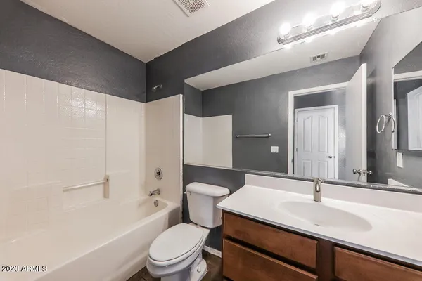 a bathroom with a sink a toilet a mirror and shower