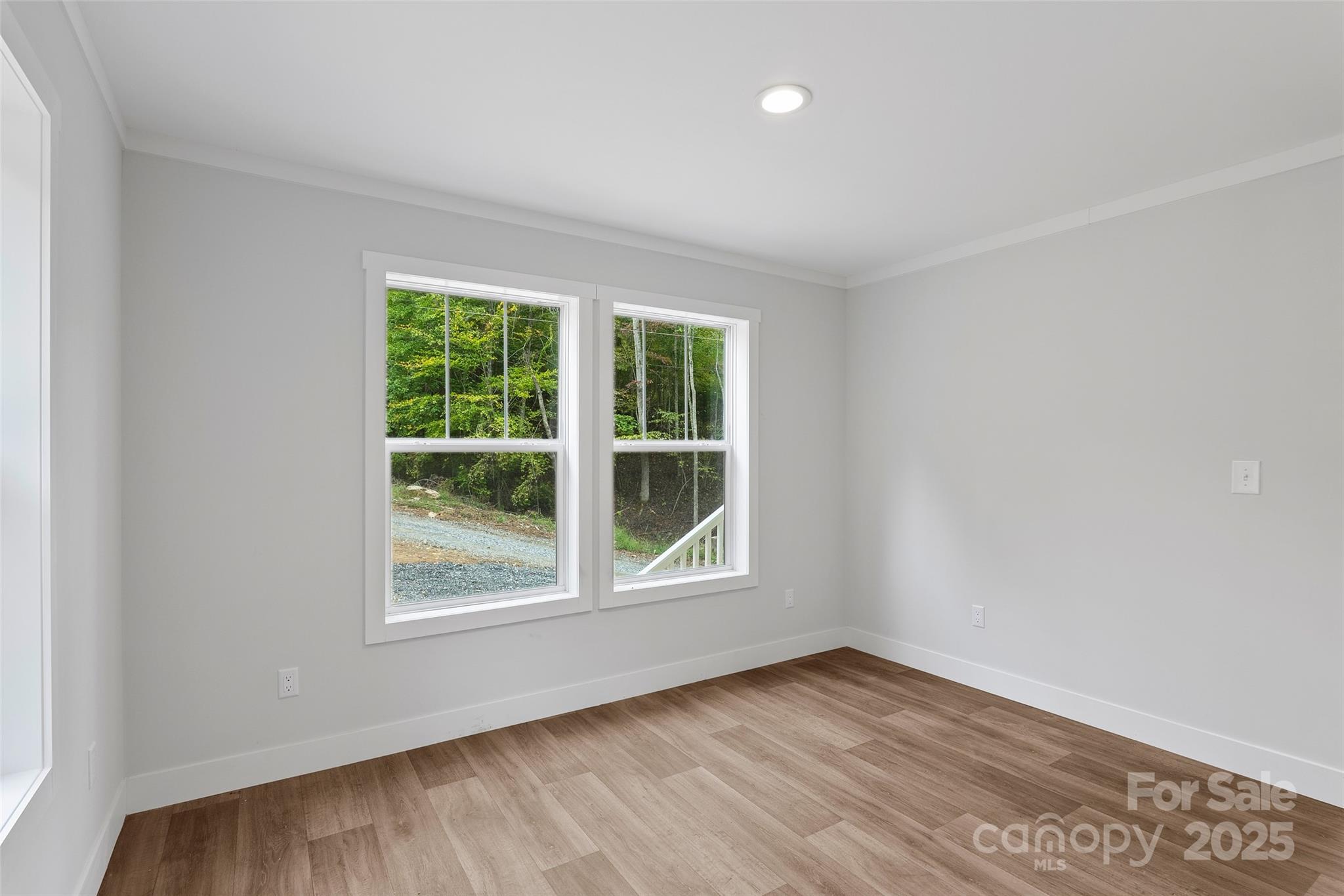 237 Hickory Nut Ridge Road, Unit 10 Burnsville, NC 28714 - Photo 16 of 42 an empty room with wooden floor and windows