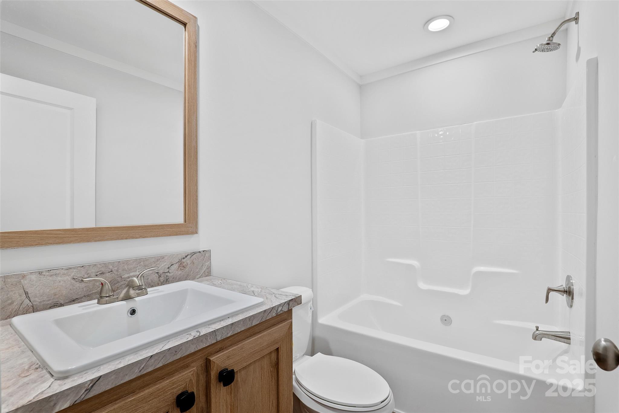 237 Hickory Nut Ridge Road, Unit 10 Burnsville, NC 28714 - Photo 24 of 42 a bathroom with a sink toilet vanity and shower