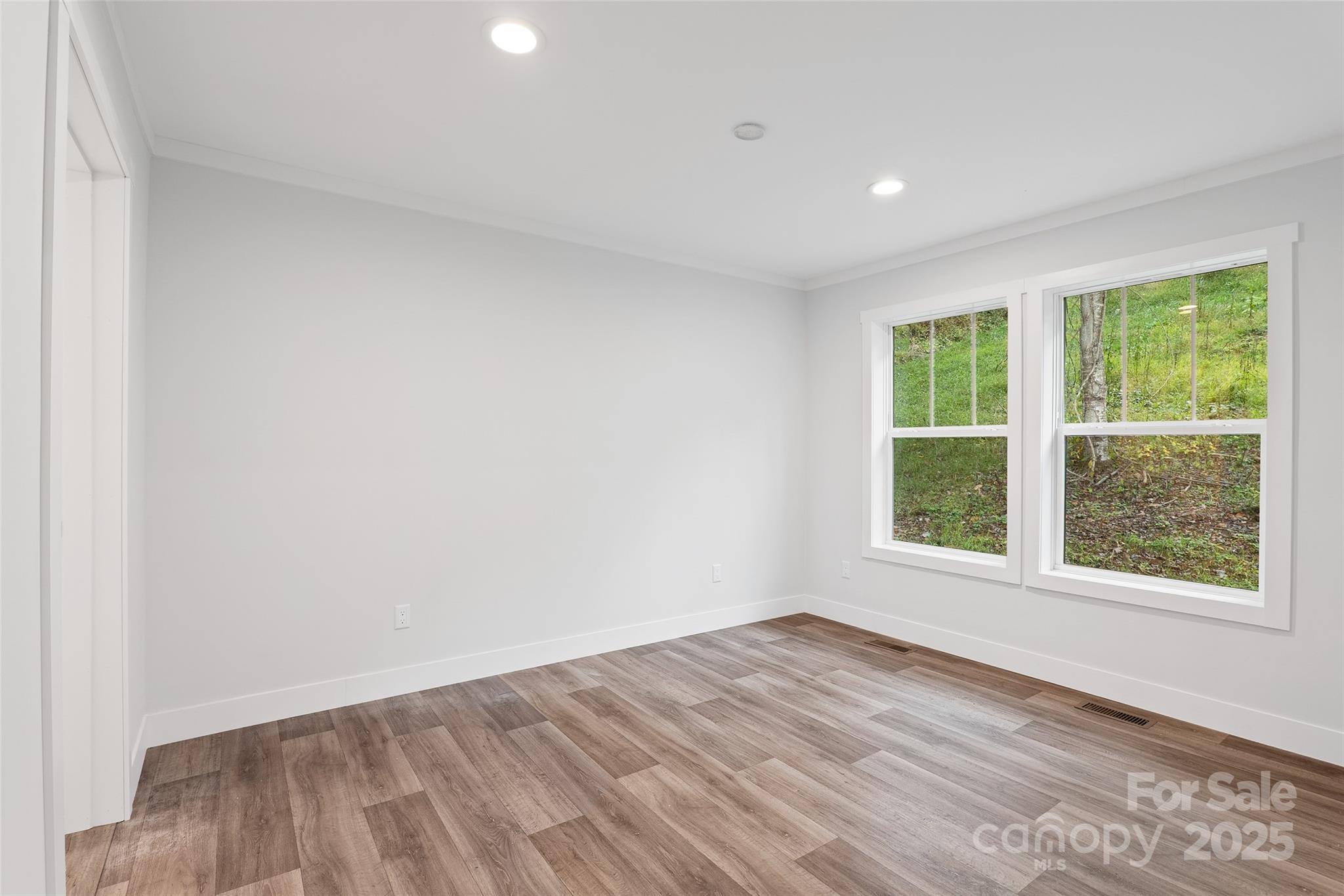 237 Hickory Nut Ridge Road, Unit 10 Burnsville, NC 28714 - Photo 30 of 42 an empty room with wooden floor and windows