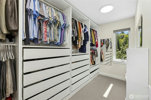 a view of walk in closet with clothes and shoes