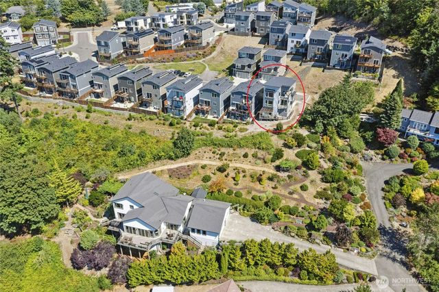 an aerial view of residential house with outdoor space and trees all around