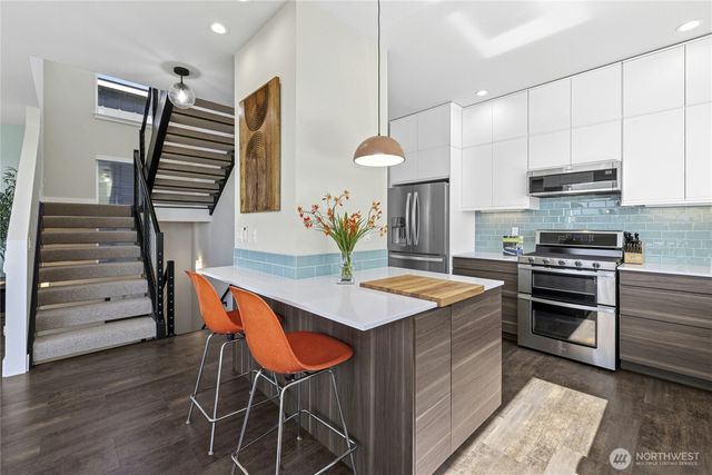 a kitchen with stainless steel appliances granite countertop a sink and a stove