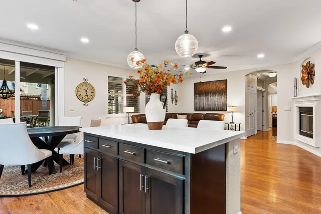a view of a dining room kitchen with furniture a chandelier and wooden floor