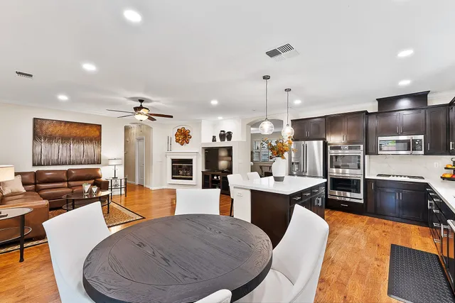 a living room with stainless steel appliances furniture and a view of kitchen