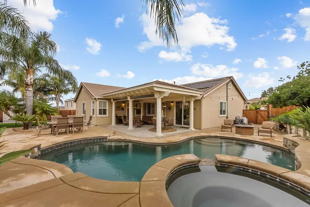 a view of a house with pool and sitting area