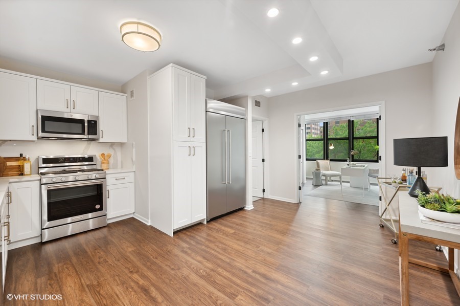 55 West Delaware Place, Unit 415 Chicago, IL 60610 - Photo 12 of 41 a living room with stainless steel appliances furniture a flat screen tv and a kitchen view