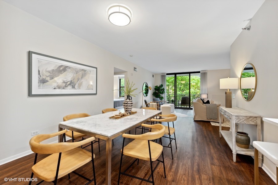 55 West Delaware Place, Unit 415 Chicago, IL 60610 - Photo 15 of 41 a view of a dining room with furniture a potted plant and wooden floor
