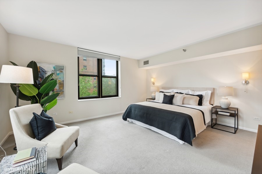 55 West Delaware Place, Unit 415 Chicago, IL 60610 - Photo 19 of 41 a spacious bedroom with a bed and a window